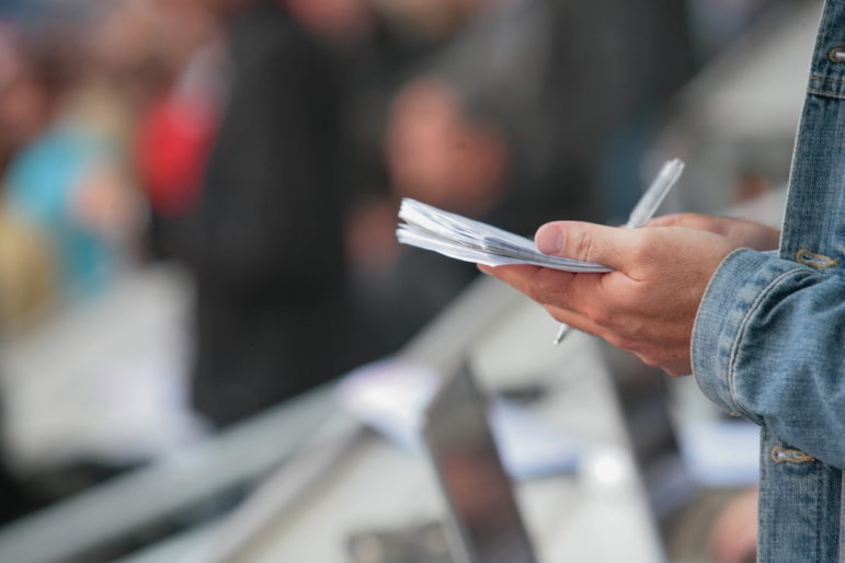 Reporter Writing in Notebook