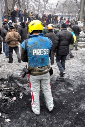 Un periodista usa chaleco y casco antibalas en Kiev, Ucrania. Imagen: Shutterstock